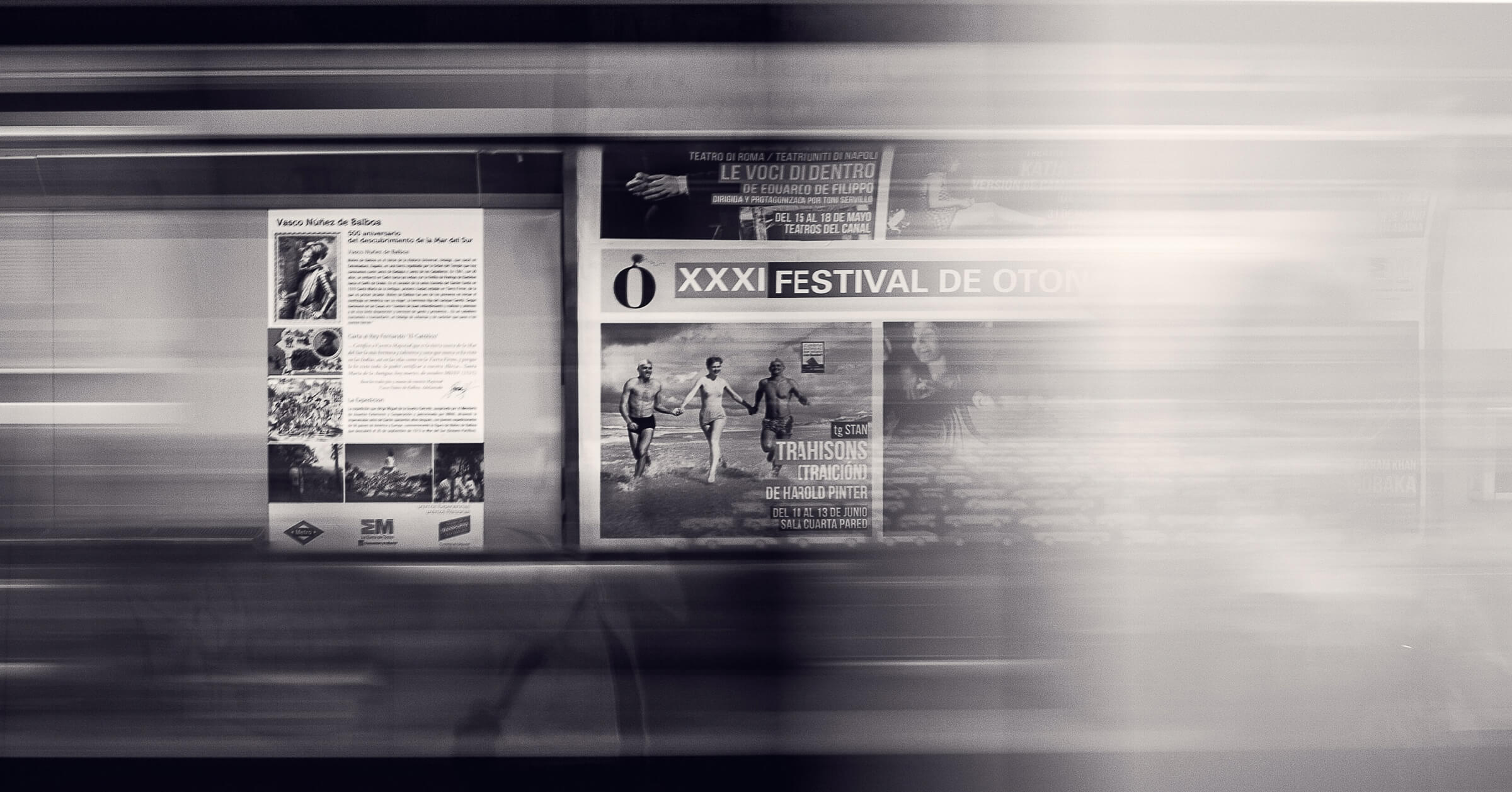 A photo of newspapers on a subway wall, blurred by the train whizzing by