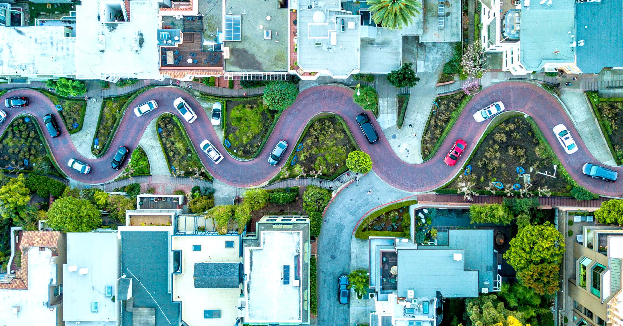 An overhead shot of cars slowly zigzagging down Lombard Street in San Francisco
